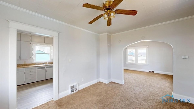 spare room with arched walkways, visible vents, ornamental molding, and a healthy amount of sunlight