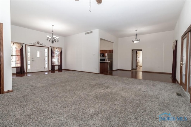 2121 County Road 4 Unit 1, Swanton, OH 43558 - unfurnished living room with visible vents, baseboards, carpet, and an inviting chandelier