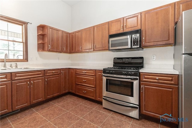 2121 County Road 4 Unit 1, Swanton, OH 43558 - kitchen with a sink, stainless steel appliances, brown cabinets, and light countertops
