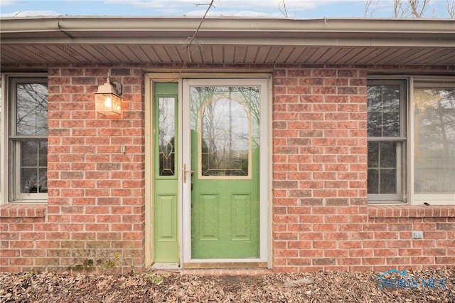 doorway to property featuring brick siding