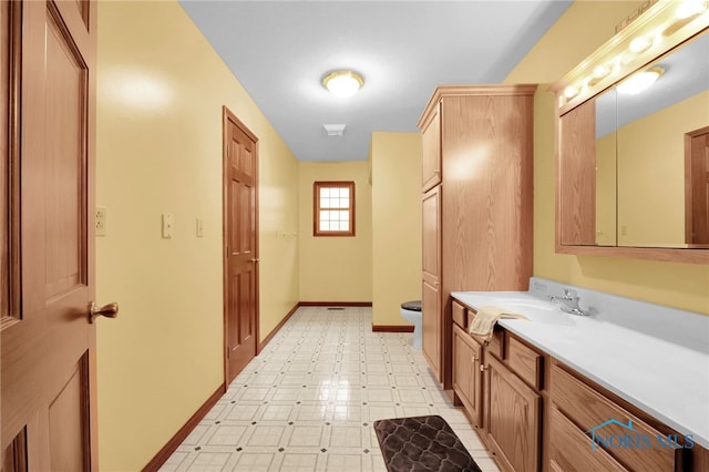 bathroom with vanity, tile patterned floors, toilet, and baseboards