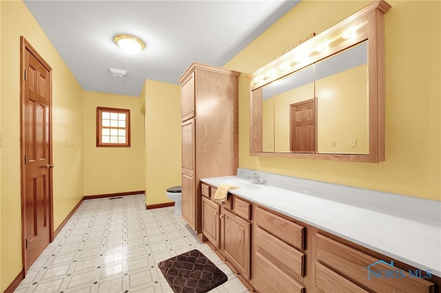 bathroom with tile patterned floors, baseboards, toilet, and vanity