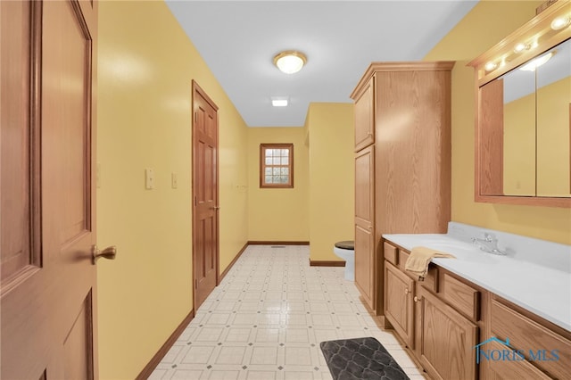 bathroom with vanity, tile patterned floors, toilet, and baseboards