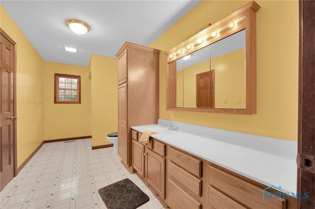 bathroom with tile patterned floors, baseboards, toilet, and vanity
