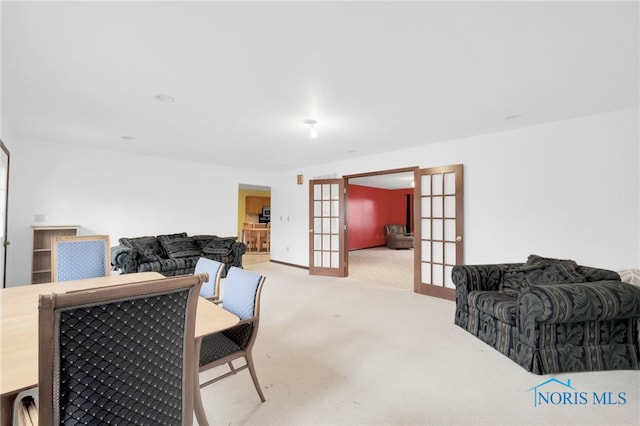 dining room featuring french doors and light carpet