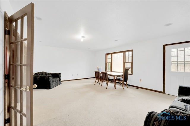 interior space featuring visible vents, light colored carpet, and baseboards