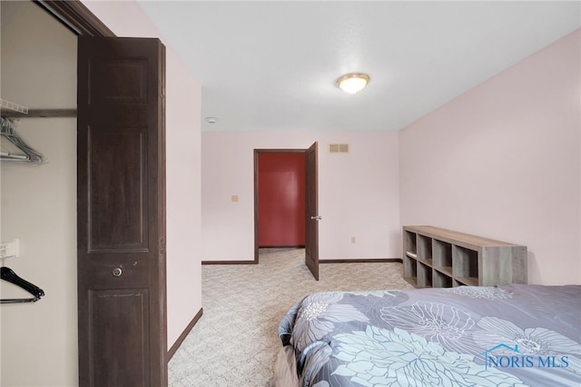bedroom featuring visible vents, baseboards, and light colored carpet