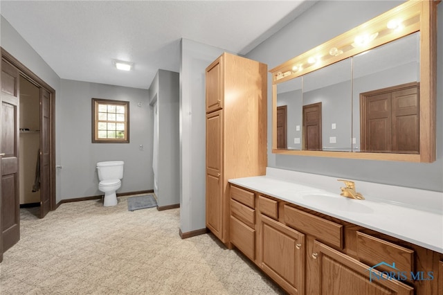 full bath with toilet, vanity, and baseboards