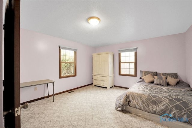 carpeted bedroom with visible vents and baseboards