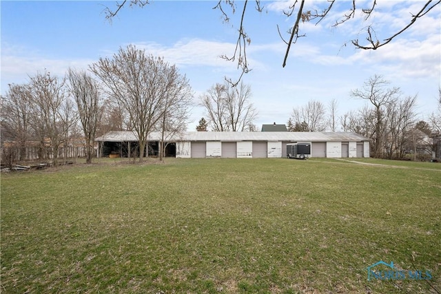 view of front of home featuring a detached garage and a front lawn