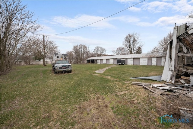 view of yard featuring a garage and fence