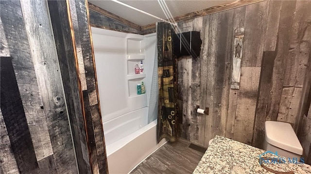 bathroom featuring shower / tub combo and toilet