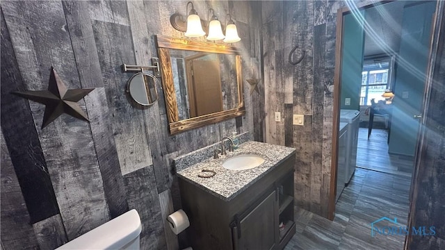 bathroom featuring vanity, toilet, a chandelier, and washing machine and clothes dryer