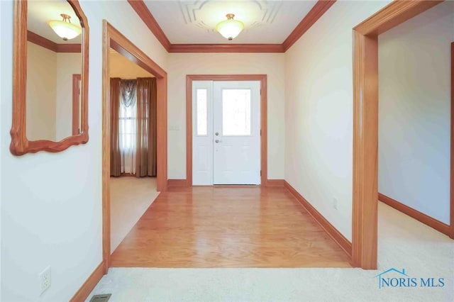 entryway featuring baseboards, ornamental molding, and light wood-style flooring