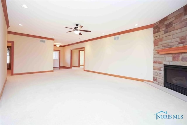 unfurnished living room with baseboards, visible vents, ornamental molding, and a fireplace