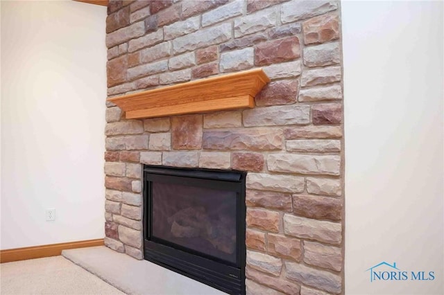 room details featuring a stone fireplace and baseboards