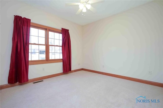 unfurnished room with carpet floors, baseboards, ceiling fan, and visible vents