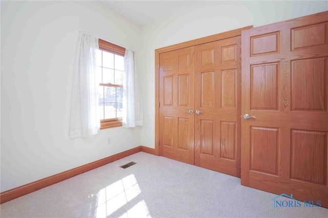 carpeted bedroom featuring baseboards, visible vents, and a closet