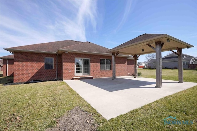 rear view of property with a patio, brick siding, and a yard