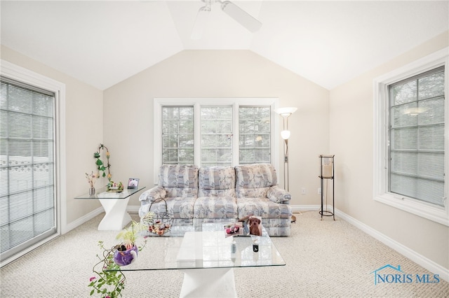 living area with baseboards, lofted ceiling, carpet floors, and a ceiling fan