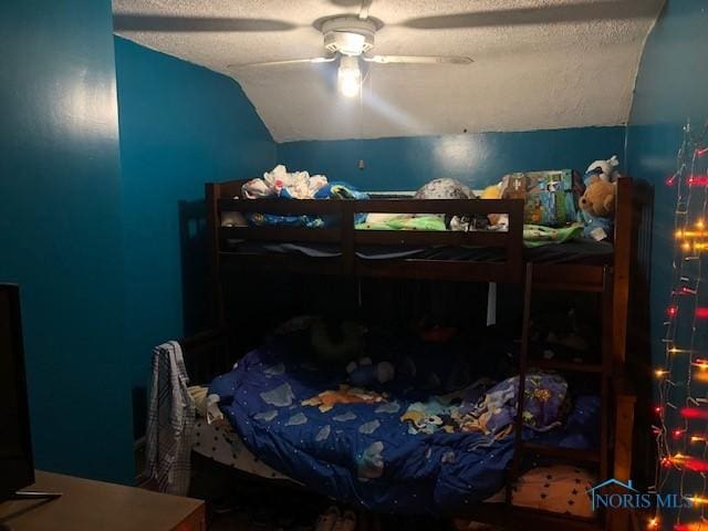 bedroom featuring vaulted ceiling, ceiling fan, and a textured ceiling