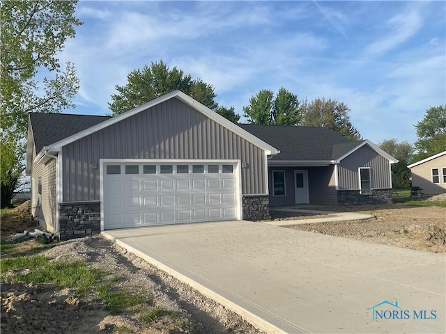 516 Ogen St, Hicksville, OH 43526 - ranch-style home with stone siding, board and batten siding, and an attached garage