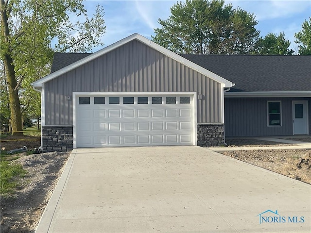 516 Ogen St, Hicksville, OH 43526 - view of front of house with stone siding, a garage, and concrete driveway