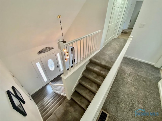 stairs featuring visible vents, high vaulted ceiling, carpet, and baseboards