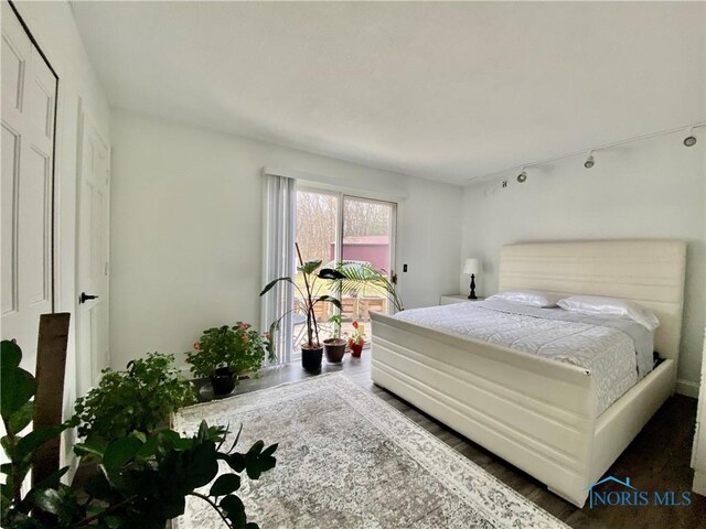 bedroom featuring access to exterior and wood finished floors