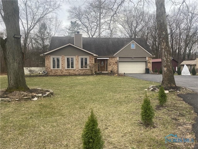 view of front of house with aphalt driveway, a chimney, a garage, brick siding, and a front lawn