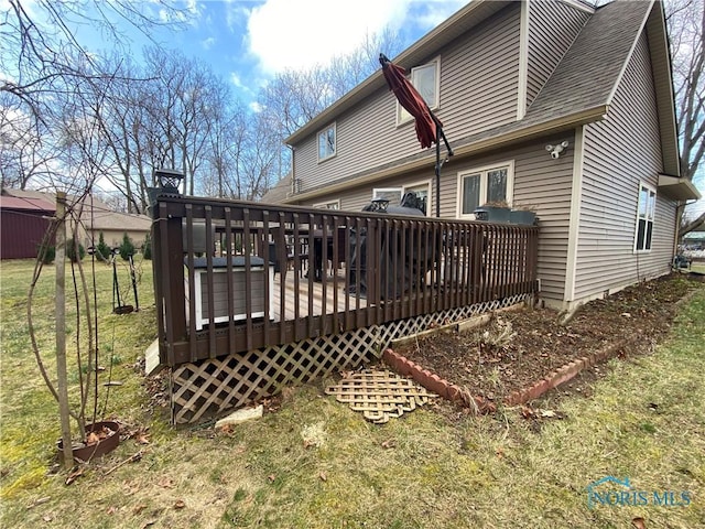 rear view of house with a lawn and a wooden deck