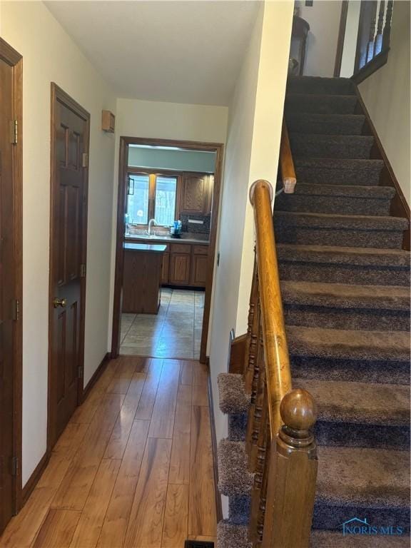 staircase with baseboards and wood finished floors