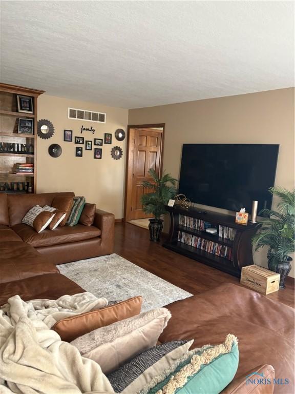 living room with visible vents and wood finished floors