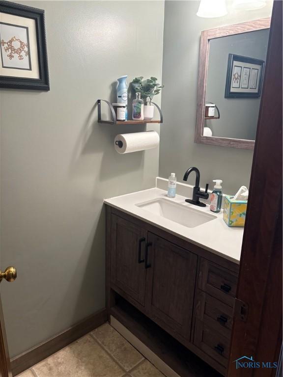 bathroom with tile patterned floors, baseboards, and vanity