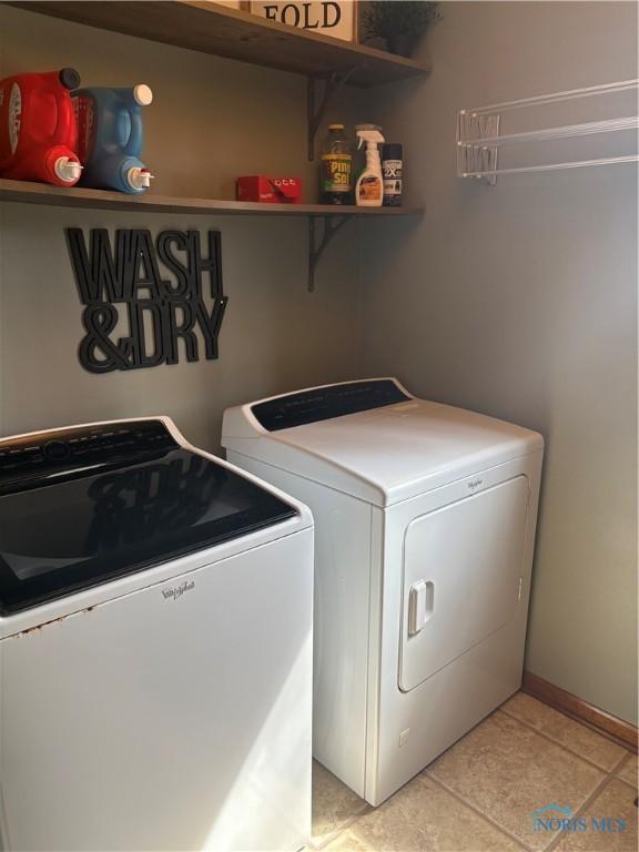 laundry room with light tile patterned floors, washer and clothes dryer, and laundry area