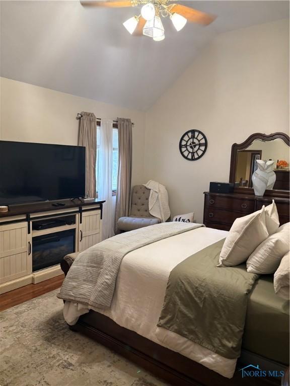 bedroom with lofted ceiling, ceiling fan, and wood finished floors