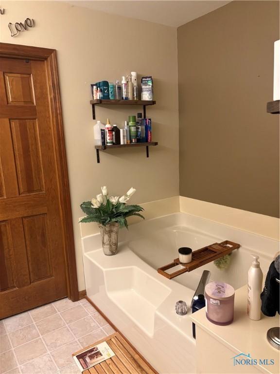 bathroom featuring tile patterned floors and a garden tub