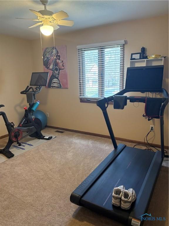 exercise room featuring baseboards, carpet flooring, ceiling fan, and visible vents