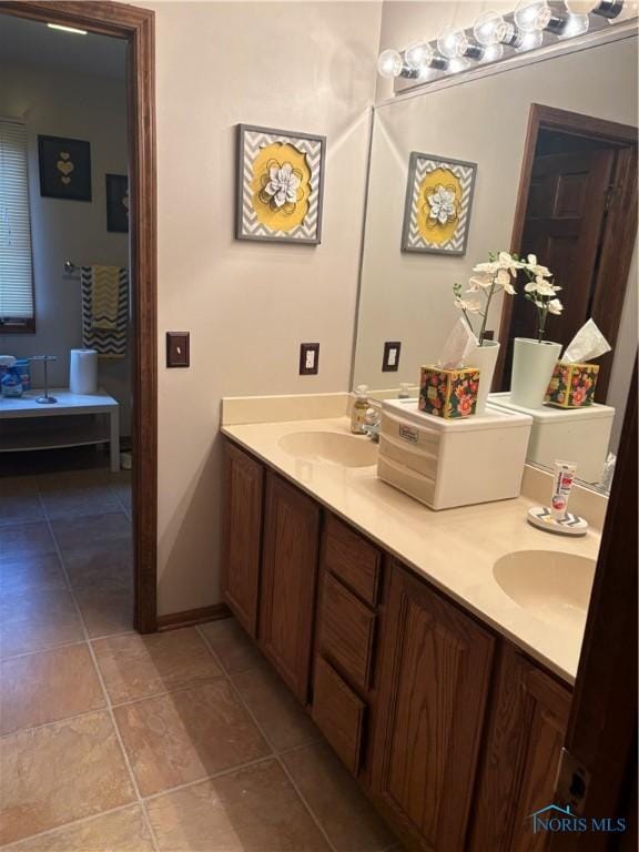 full bathroom with double vanity, a sink, and tile patterned floors