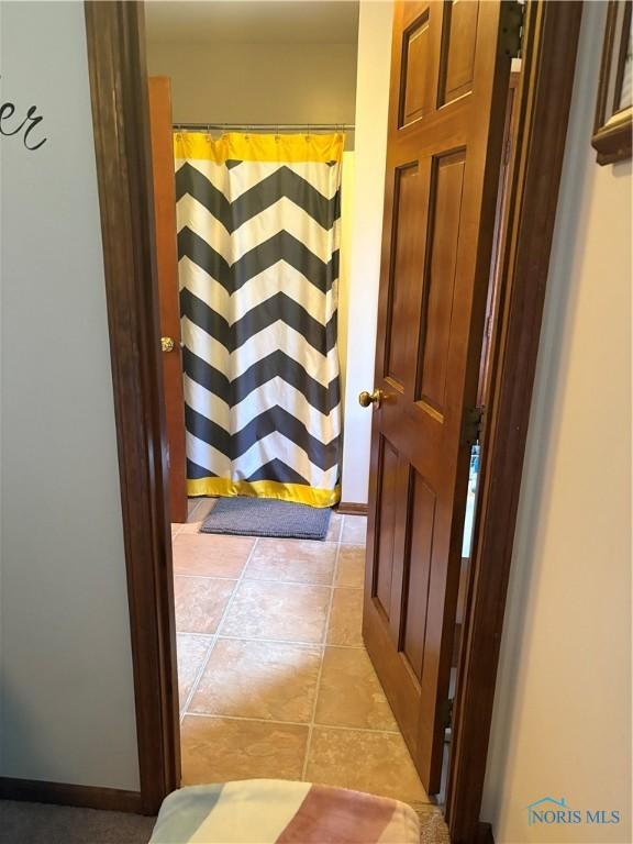 hall with light tile patterned floors and baseboards