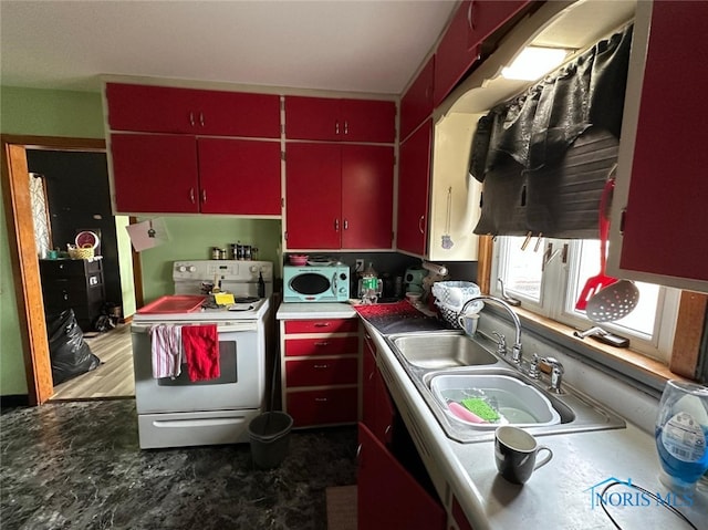 kitchen featuring electric range, red cabinetry, a sink, and yellow cabinets