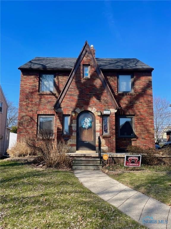 3805 Grantley Rd, Toledo, OH 43613 - tudor house featuring brick siding, a shingled roof, and a front lawn