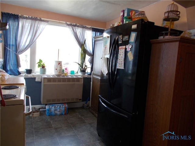 kitchen with white electric range oven, freestanding refrigerator, and heating unit