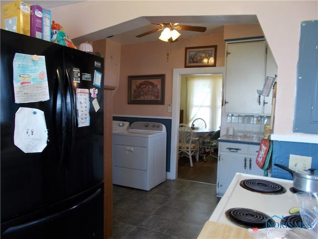 kitchen featuring freestanding refrigerator, a ceiling fan, cooktop, washer and clothes dryer, and dark tile patterned flooring