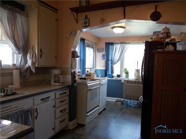 kitchen with tasteful backsplash, white cabinets, plenty of natural light, and white stove