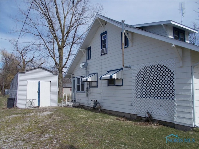 rear view of house with an outbuilding, a storage unit, and a yard