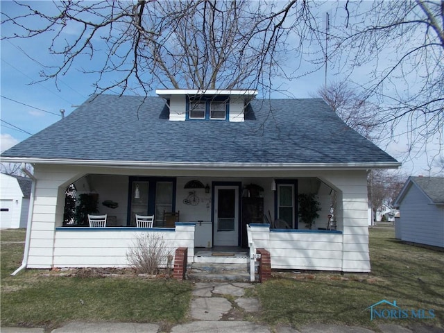 bungalow-style house featuring a porch, roof with shingles, and a front yard