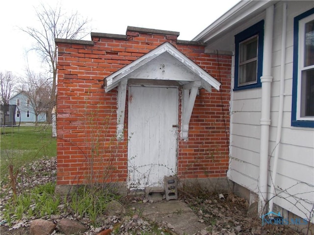 view of exterior entry with brick siding