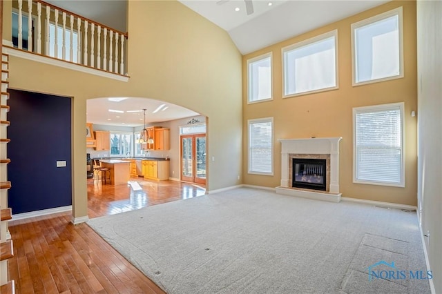 14579 Lake Meadows Dr, Perrysburg, OH 43551 - unfurnished living room with high vaulted ceiling, a premium fireplace, baseboards, a ceiling fan, and arched walkways