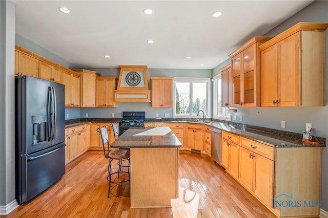 14579 Lake Meadows Dr, Perrysburg, OH 43551 - kitchen featuring a sink, a kitchen island, a breakfast bar area, light wood-type flooring, and black appliances